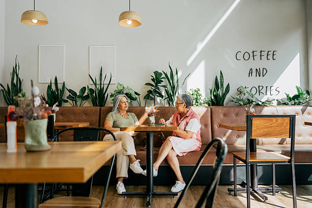 Two female friends chatting while drinking coffee in a cafe