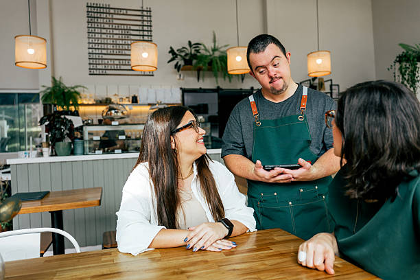 istock Man with down syndrome taking order in coffee shop, working as waiter 2209425372