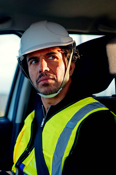 istock Engineer wearing hardhat and safety vest driving a car 2209427241