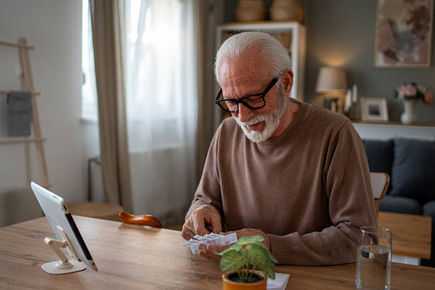 istock Senior man taking medicine at home using digital tablet 2209427762