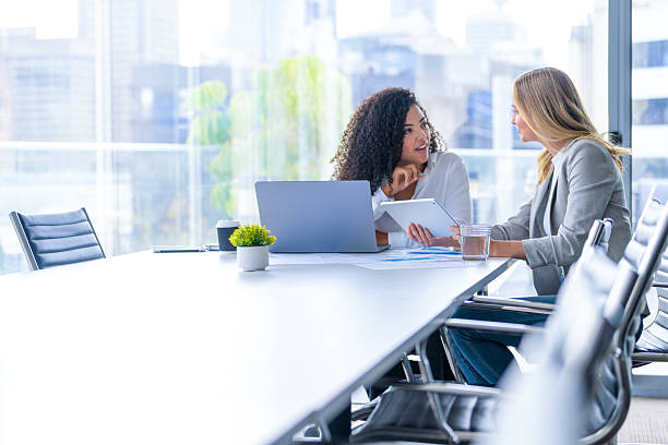 istock Business colleagues having a conversation. They are both young business people casually dressed in a modern office. 2209428144