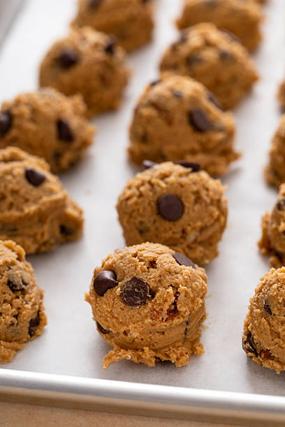 istock Chocolate chip cookies with pecan nuts, cookie dough ready on a baking sheet 2209429852