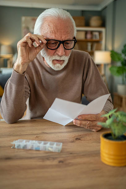 istock Senior man reading medical instructions at home 2209430363
