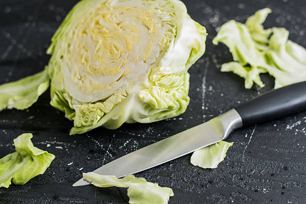 istock Half of the green cabbage lies on a dark surface 2209430855