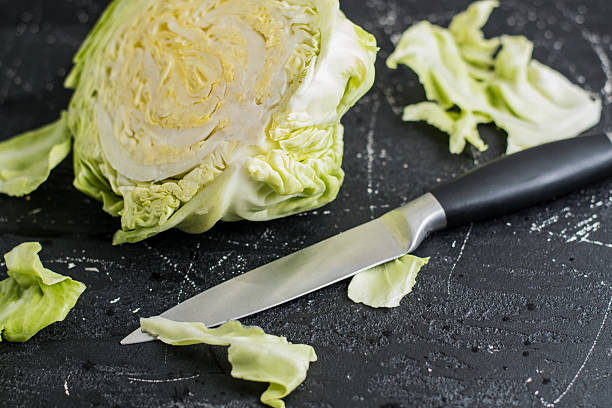 istock Half of the green cabbage lies on a dark surface 2209430859