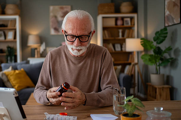 istock Senior man taking medication at home using a pill organizer 2209431291