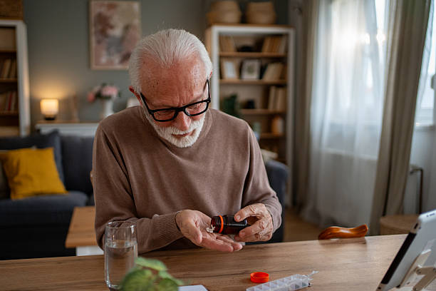 istock Senior man taking medication at home following doctor's instructions 2209431684