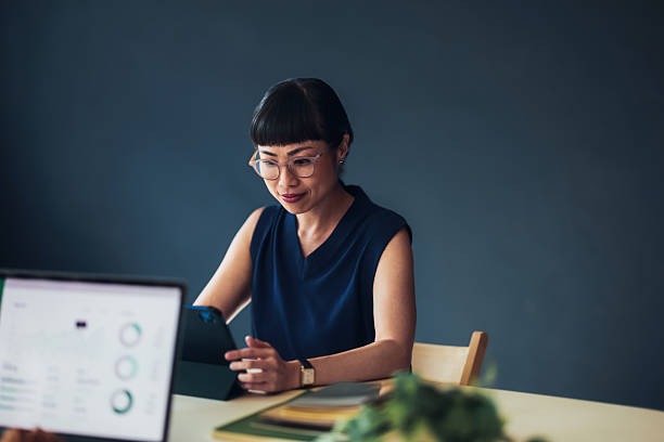Professional Woman Working on Tablet in Modern Office Setting