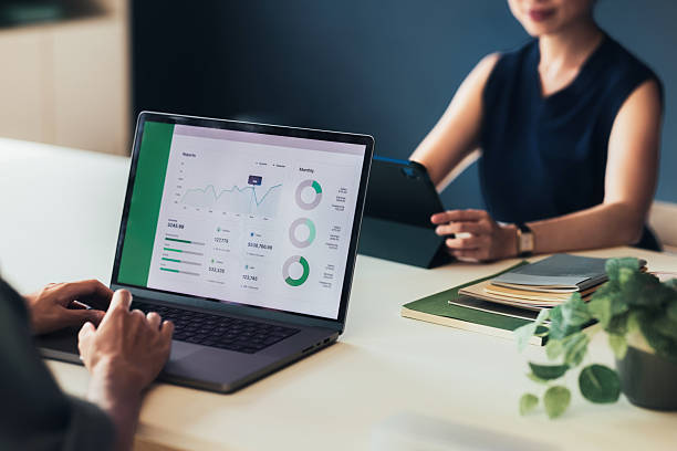 Professionals Analyzing Business Performance Data on Digital Devices in an Office Meeting