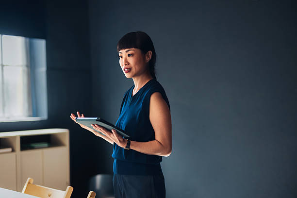 Confident Businesswoman Presenting with Digital Tablet in Modern Office Environment