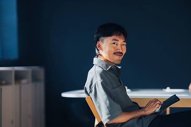 istock Young Professional Holding a Digital Tablet Looking Confident in a Modern Office Setting 2209432147