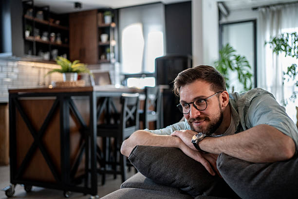 istock Young man relaxing on sofa in modern apartment, enjoying peaceful moment 2209435031