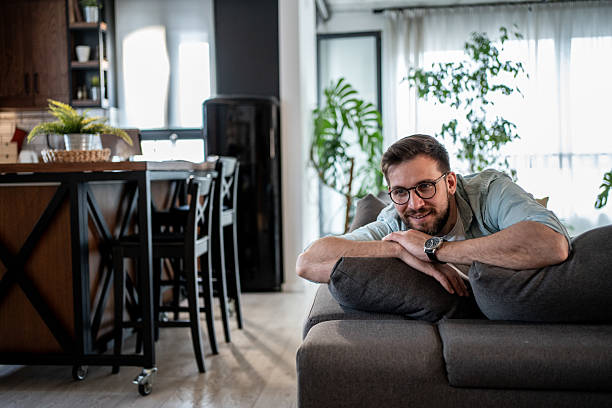 istock Young man relaxing on sofa in modern apartment 2209435045