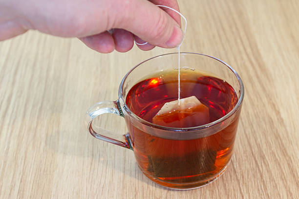 istock A man's hand makes a tea bag in a mug of water. 2209438583