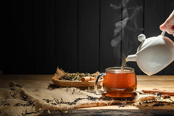 istock Pour hot tea into cups, herbal tea glasses are arranged on a rustic wooden table. 2209444702