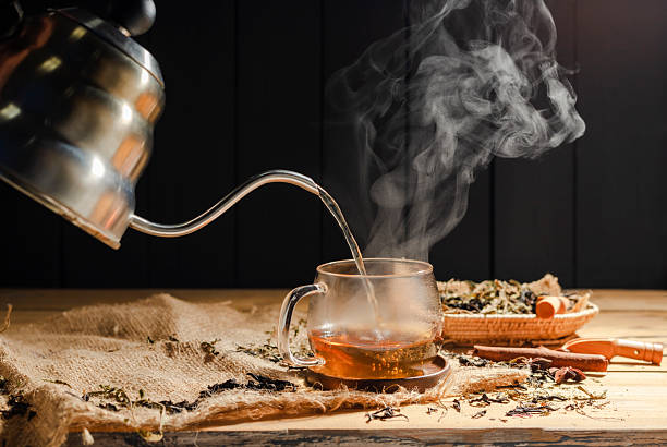 istock Pour hot tea into cups, herbal tea glasses are arranged on a rustic wooden table. 2209444705