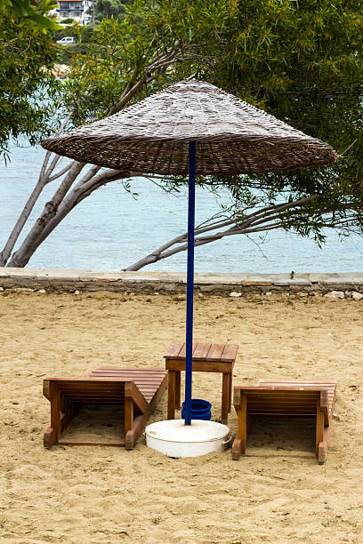istock A beach with straw umbrellas, empty wooden chairs 2209444916