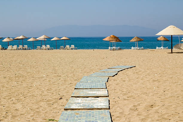 A beach with umbrellas and chairs on the beach in the background. summer holidays and vacation concept