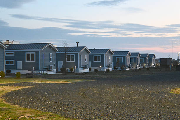 Row of identical blue single multiple generic Modern camping cabins tiny homes in a line on beach