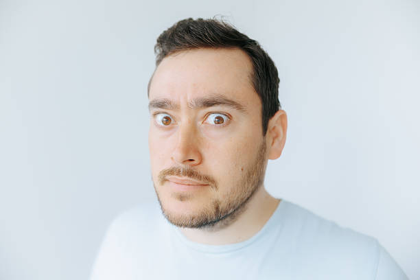 istock Man with wide eyes shows surprise in a light, casual setting 2209457317