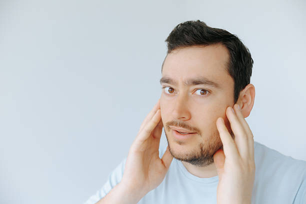 istock Person showing expression of concern while touching face in bright room 2209457329