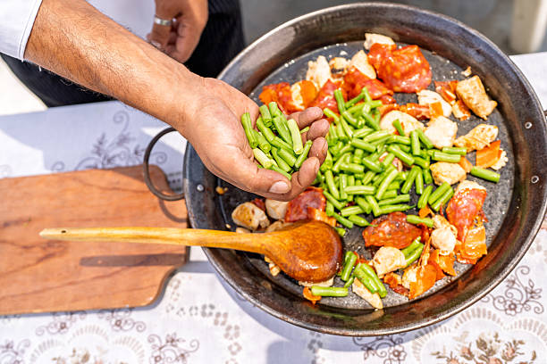istock Chef adding green beans to paella with chicken and chorizo 2209462367
