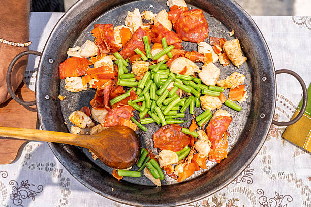 istock Chef adding green beans to paella with chicken and chorizo 2209462369