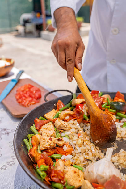istock Chef preparing delicious paella outdoors for family gathering 2209462404
