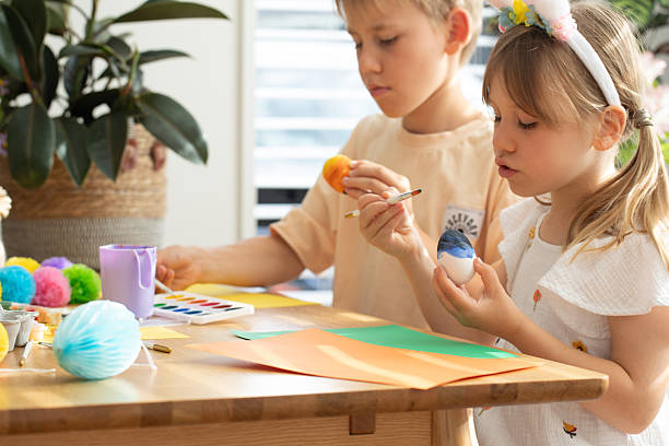 istock Brother and sister painting Easter eggs. Happy Easter concept 2209462693