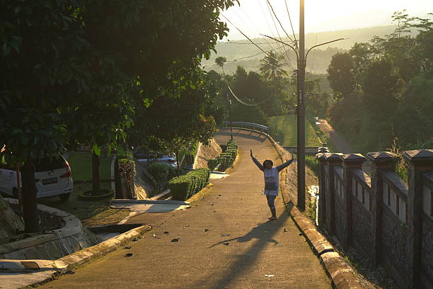 March 6, 2025 - Celebrating the early morning after sunrise, a member of an Indonesian family walks back towards their villa accommodation at the Giri Tirta Kahuripan mountain resort in Purwakarta, West Java, during the post-Eid al-Fitr (Lebaran) holiday break.