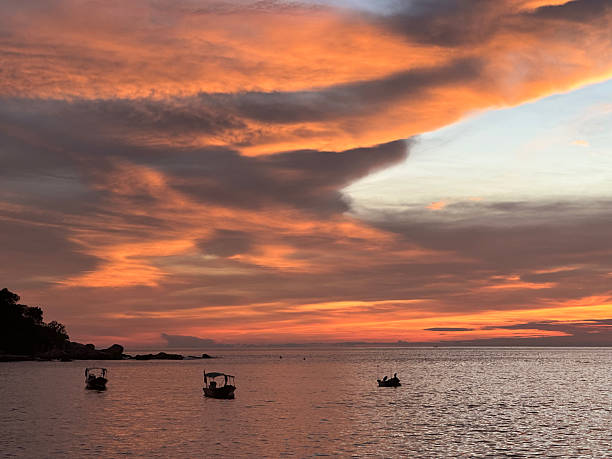 istock sunset on the beach with boats and island 2209474448