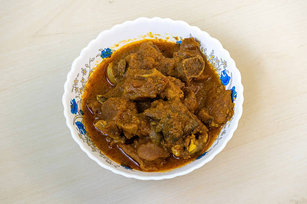 istock Delicious mutton curry in a white bowl on a light wooden table background. Mutton bhuna is a very tasty, spicy, and popular Bengali (Bangladesh) dish. 2209475729