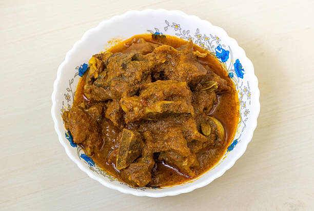 istock Delicious mutton curry in a white bowl on a light wooden table background. Mutton bhuna is a very tasty and spicy dish, popular in Bengali (Bangladesh) cuisine. 2209475785