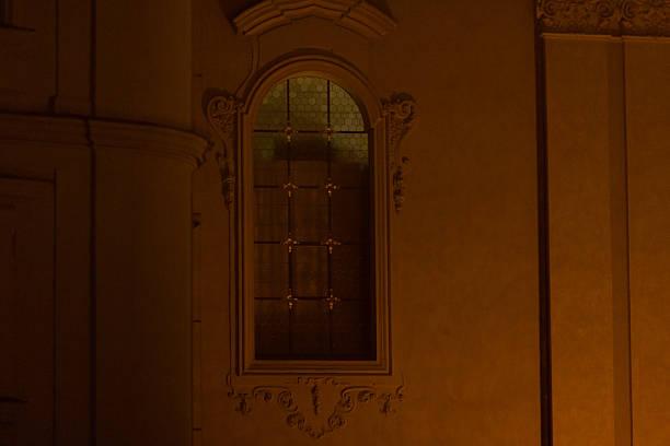 Iron gate window showcases an intricate design set at night in old town.