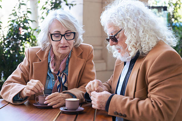 istock Caucasian senior couple talking closely while drinking coffee at outdoor cafe 2209480702