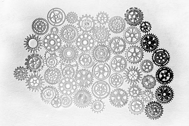 Cogs and gear wheels arranged on slate rock background showing textures and patterns in engineering metal work Asia