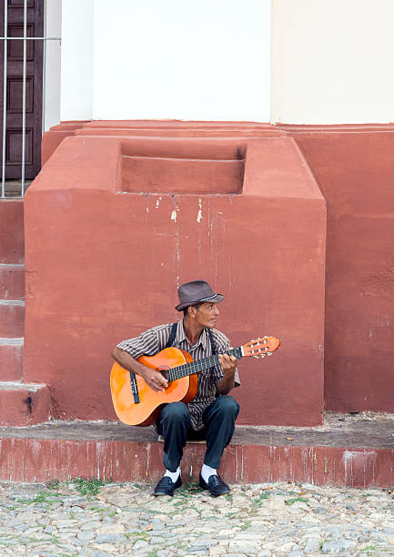 Close-up of senior man playing acoustic guitar at home