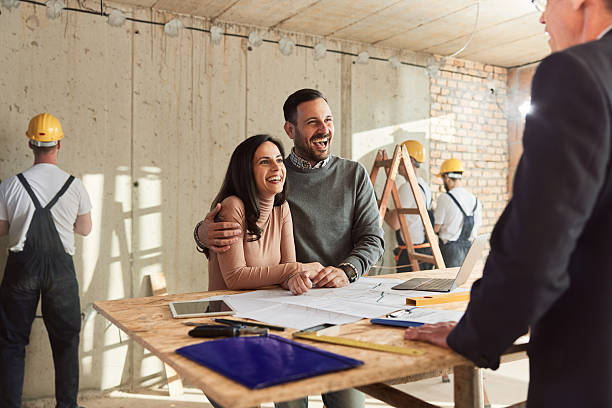 istock Happy couple talking about plans with their architect at construction site. 2209485186