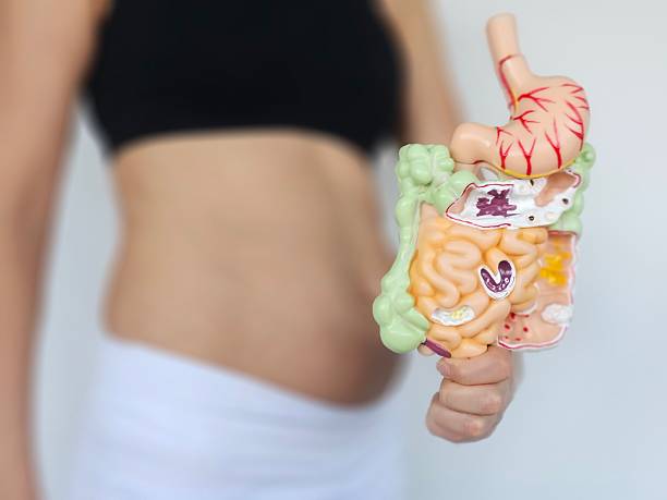 istock Stomach ache, bloating, flatulence, abdominal distension, colic, digestive disorders. A young woman holding her stomach. Overeating, overweight, excess weight concept 2209486095