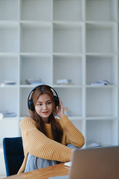 istock Young woman enjoying a relaxing music break at her desk while using headphones, writing in a notebook, and working on her laptop for calm inspiration 2209488076