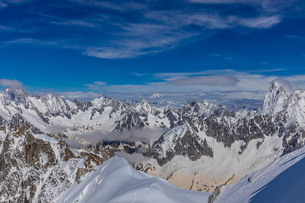 The mountain range is covered in snow and the sky is clear and blue. The snow-covered peaks are majestic and the view is breathtaking