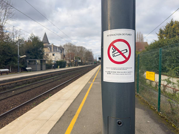 istock Quiet train station awaits passengers in a cloud-covered sky with a no smoking sign highlighting a peaceful atmosphere in a suburban area 2209490651
