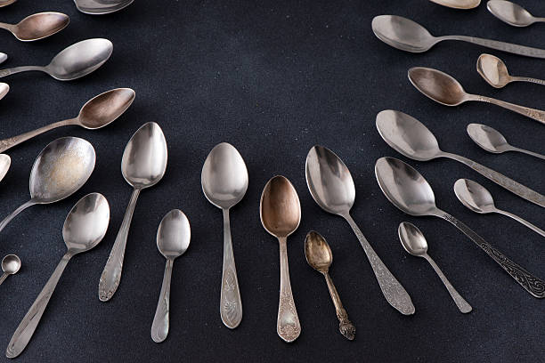 istock Set of different spoons. Silver cutlery on a black background. Spoon on the table 2209495139