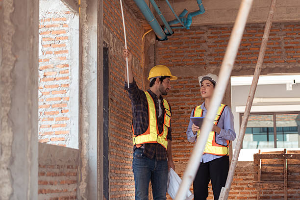 istock Architects and engineers work together to assess the residential home construction site's progress 2209497095