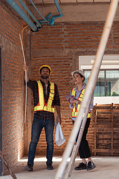 istock Architects and engineers work together to assess the residential home construction site's progress 2209497097
