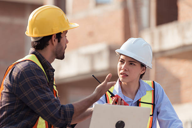 istock Architects and engineers work together to assess the residential home construction site's progress 2209497443