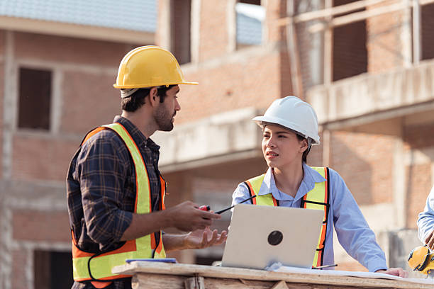 istock Architects and engineers work together to assess the residential home construction site's progress 2209497446