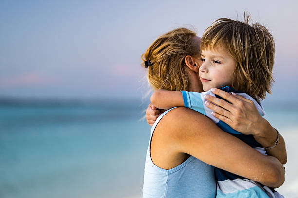 istock Loving single mother and son embracing on the beach. 2209498876