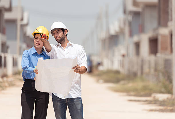 istock Architects and engineers work together to assess the residential home construction site's progress 2209499839
