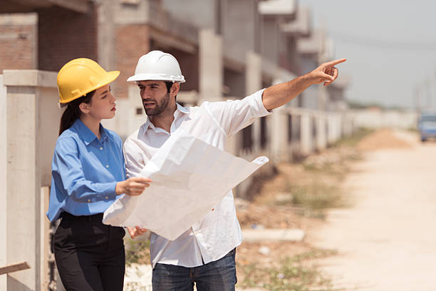 istock Architects and engineers work together to assess the residential home construction site's progress 2209499840
